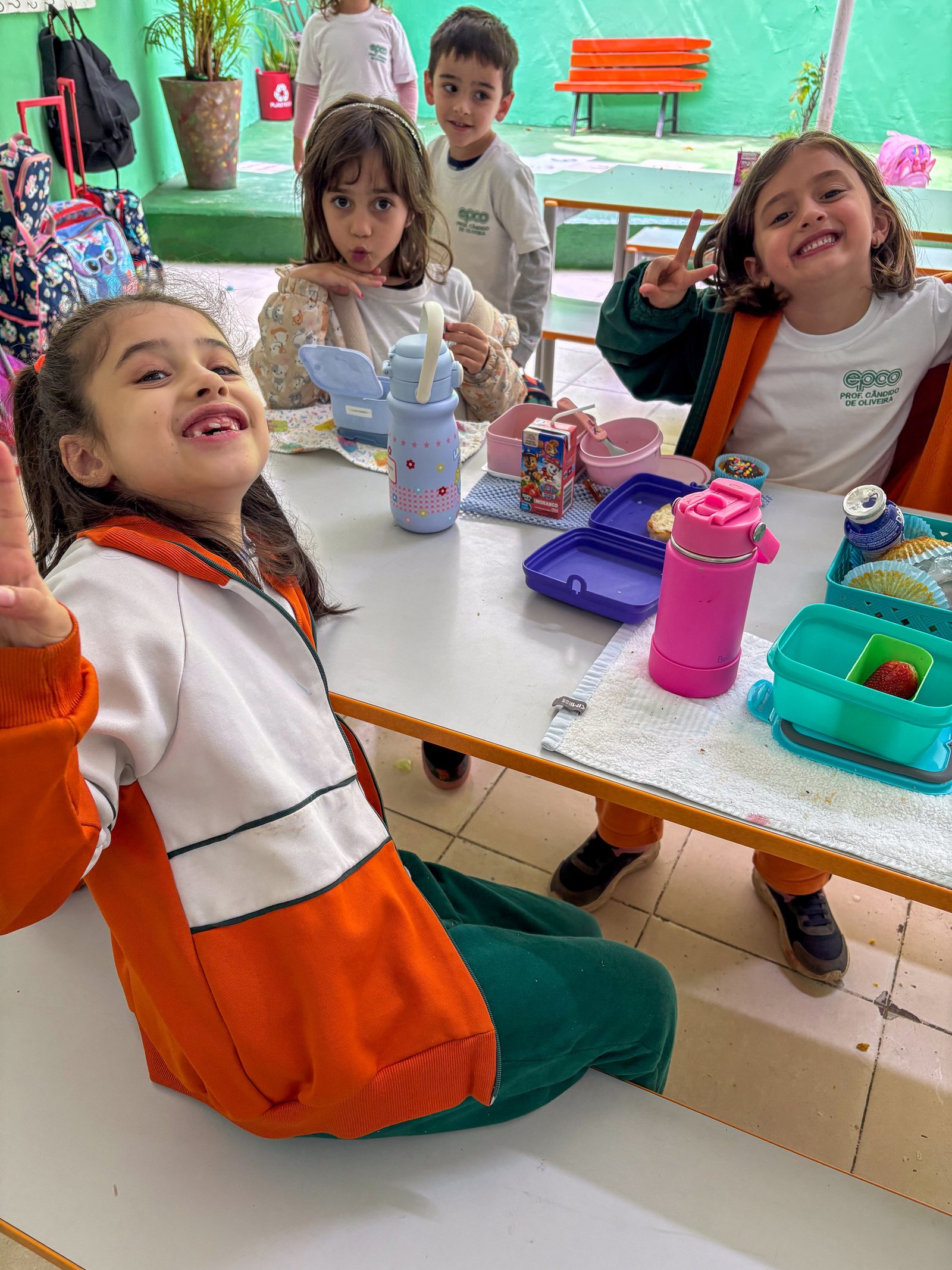Crianças sorrindo durante o lanche no refeitório