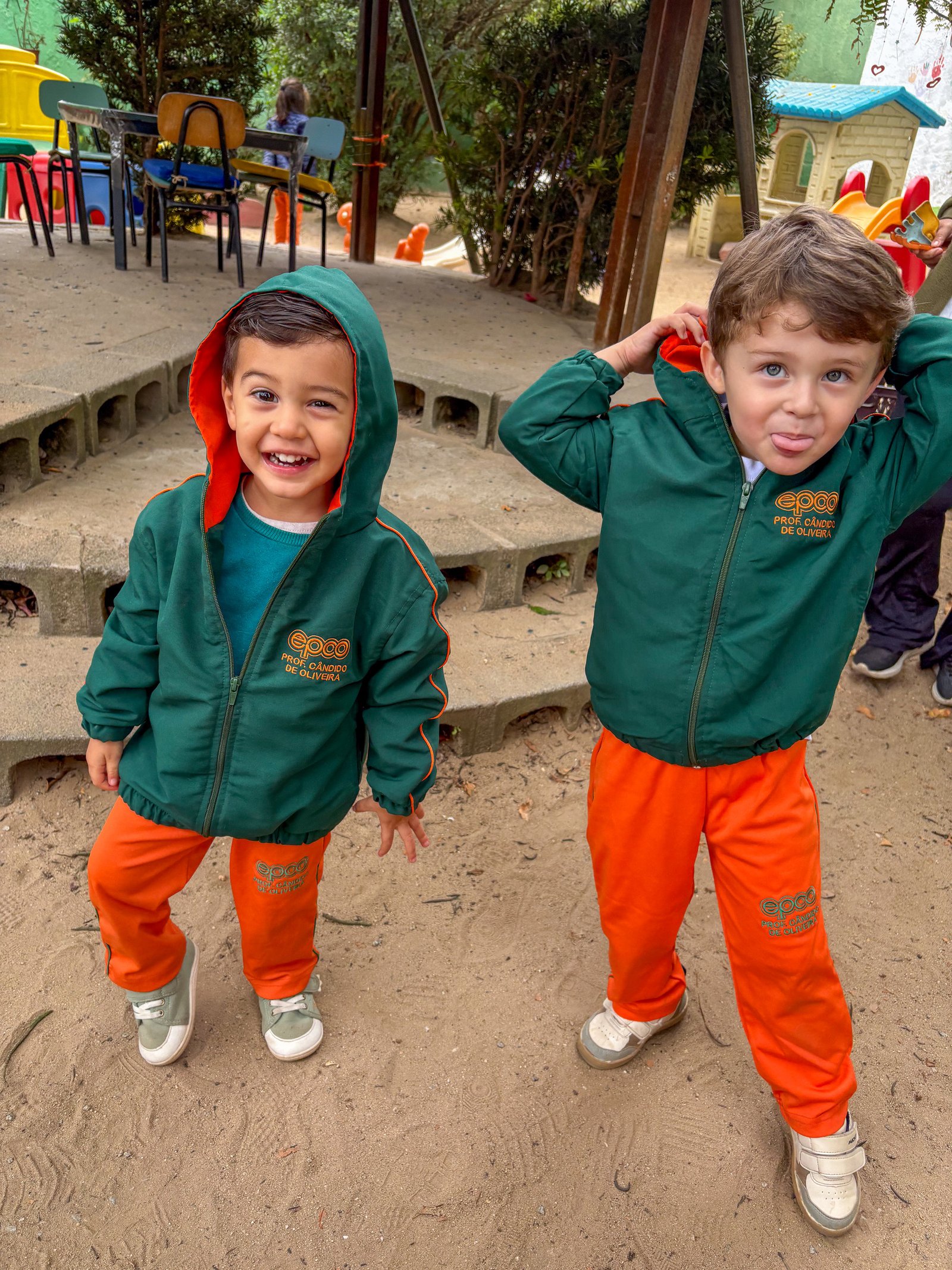 Dois alunos de uniforme se divertindo no pátio